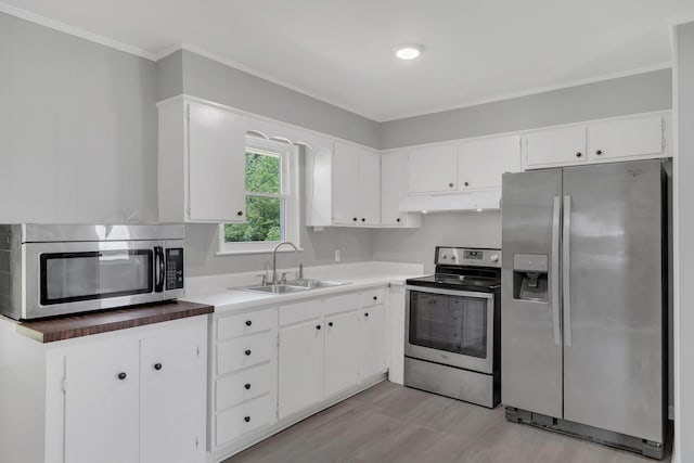 305 Thomas Ave, Hohenwald, TN 38462 - kitchen featuring light wood-style flooring, under cabinet range hood, appliances with stainless steel finishes, a sink, and white cabinetry