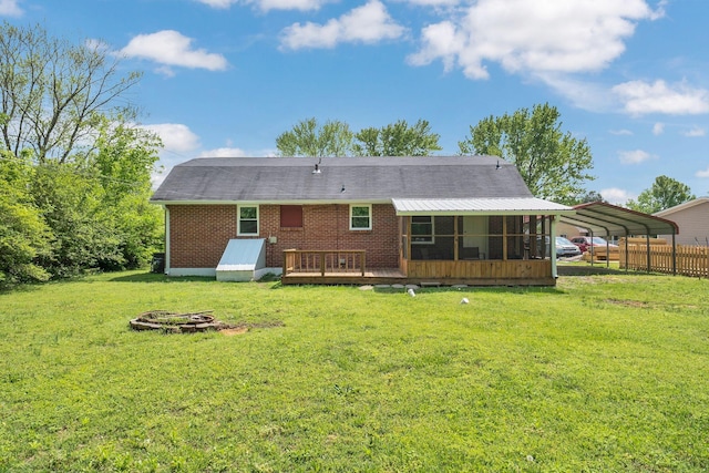 305 Thomas Ave, Hohenwald, TN 38462 - back of property with a sunroom, a lawn, a carport, brick siding, and a deck