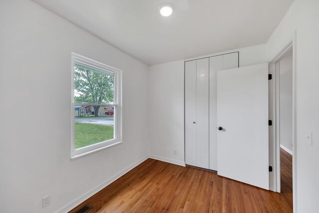 305 Thomas Ave, Hohenwald, TN 38462 - unfurnished bedroom featuring a closet, visible vents, wood finished floors, and baseboards