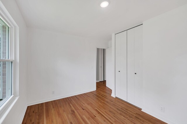 305 Thomas Ave, Hohenwald, TN 38462 - unfurnished bedroom featuring a closet, baseboards, and light wood-type flooring