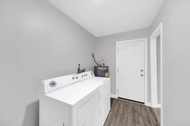 305 Thomas Ave, Hohenwald, TN 38462 - laundry room featuring wood finished floors, water heater, laundry area, washing machine and dryer, and baseboards