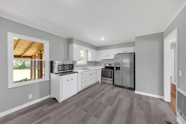 305 Thomas Ave, Hohenwald, TN 38462 - kitchen with ornamental molding, a sink, appliances with stainless steel finishes, and wood finished floors