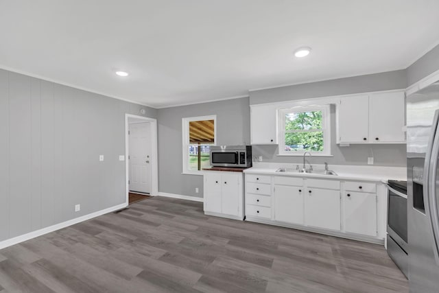 305 Thomas Ave, Hohenwald, TN 38462 - kitchen featuring crown molding, a sink, white cabinets, and appliances with stainless steel finishes