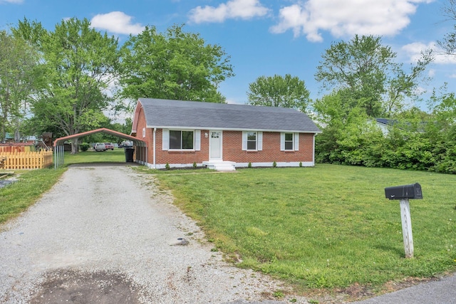 305 Thomas Ave, Hohenwald, TN 38462 - view of front of house featuring driveway, a detached carport, fence, brick siding, and a front lawn