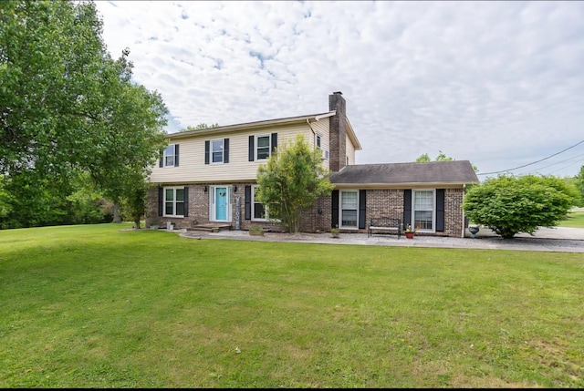 colonial inspired home featuring a front yard, brick siding, and a chimney