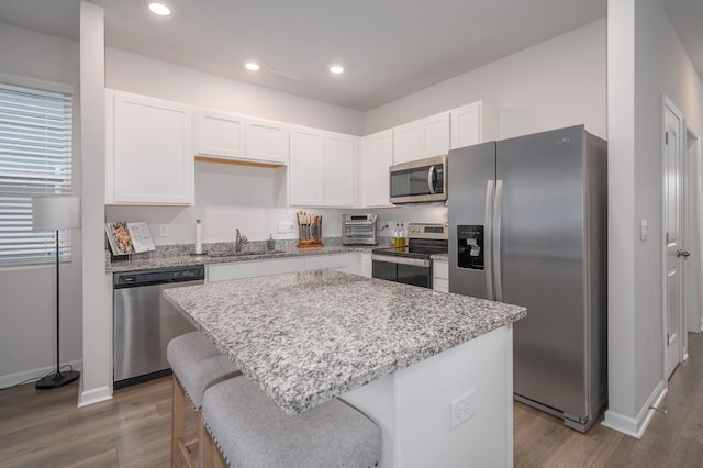 kitchen with stainless steel appliances, dark wood-style flooring, white cabinetry, and a sink