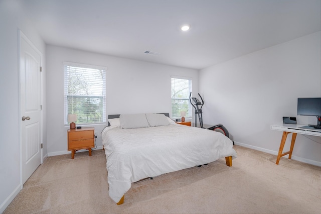bedroom featuring light carpet, visible vents, and baseboards