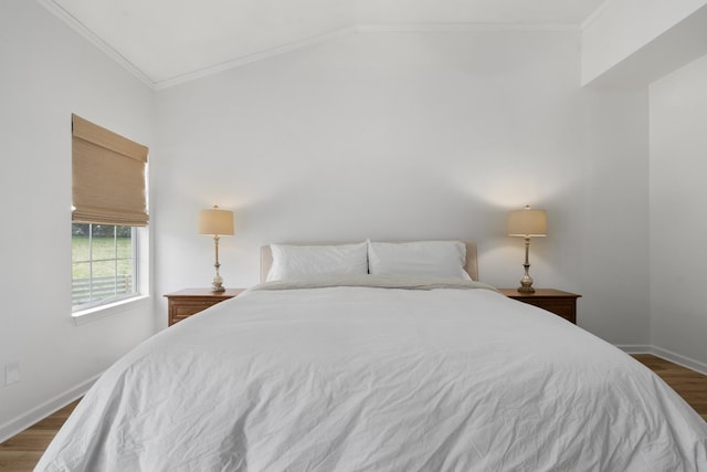 bedroom with ornamental molding, baseboards, wood finished floors, and lofted ceiling