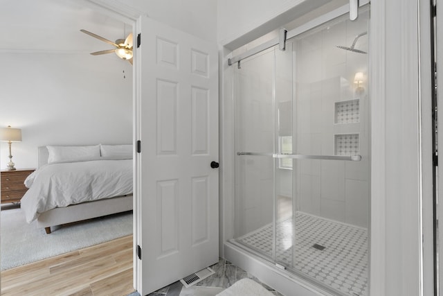 ensuite bathroom with visible vents, ceiling fan, a shower stall, and connected bathroom