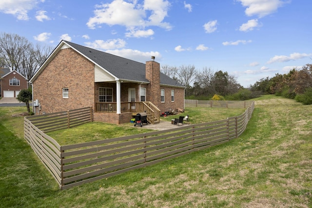 view of home's exterior with a yard, brick siding, fence, and a chimney