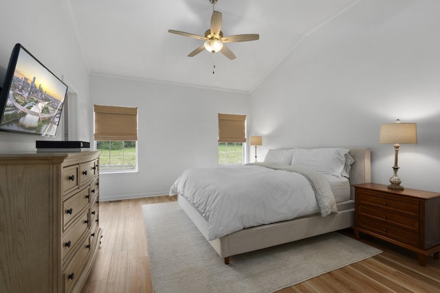 bedroom with baseboards, ornamental molding, ceiling fan, light wood-style floors, and lofted ceiling