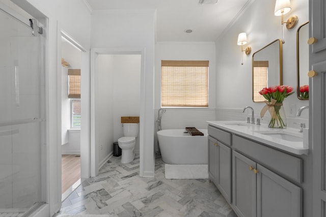 bathroom featuring a sink, a freestanding bath, a shower stall, and crown molding