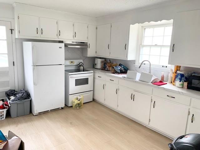 1844 Holloway Cir, Lebanon, TN 37090 - kitchen featuring white cabinetry, under cabinet range hood, light countertops, and white appliances