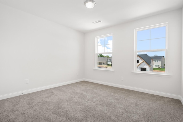 unfurnished room featuring carpet floors, visible vents, and baseboards