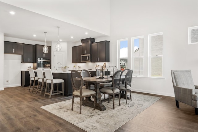 dining room featuring dark wood-type flooring, baseboards, and recessed lighting