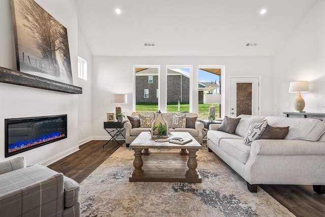 living room featuring wood finished floors, visible vents, and a wealth of natural light