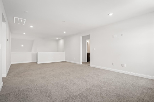 carpeted empty room featuring baseboards, visible vents, and recessed lighting