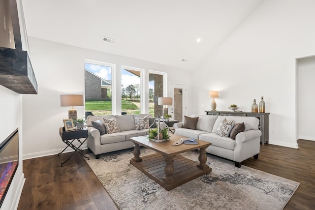 living room featuring high vaulted ceiling, baseboards, dark wood-type flooring, and visible vents