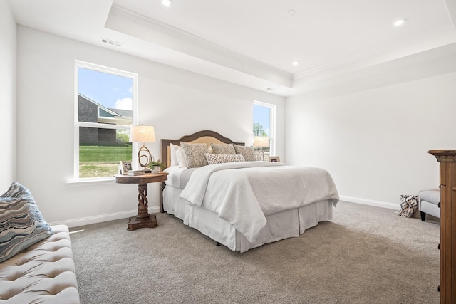 carpeted bedroom featuring baseboards, crown molding, visible vents, and a raised ceiling