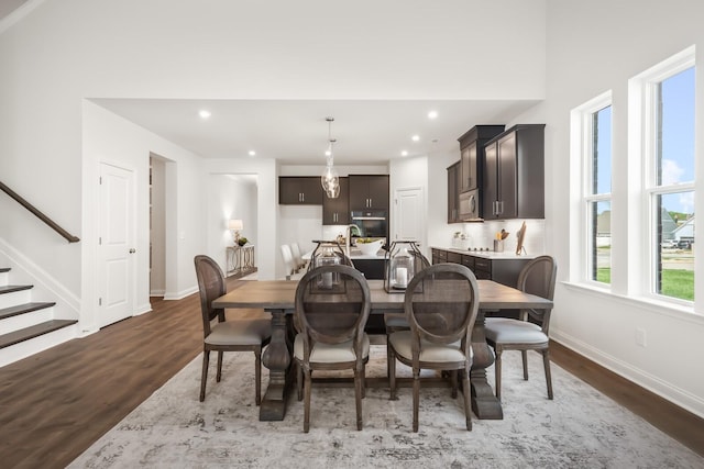 dining room with baseboards, wood finished floors, stairs, and recessed lighting