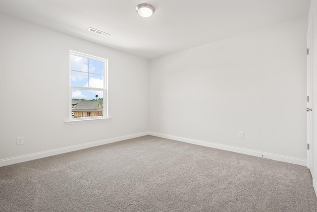 empty room featuring baseboards, carpet floors, and visible vents