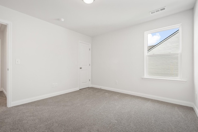 carpeted spare room with baseboards and visible vents