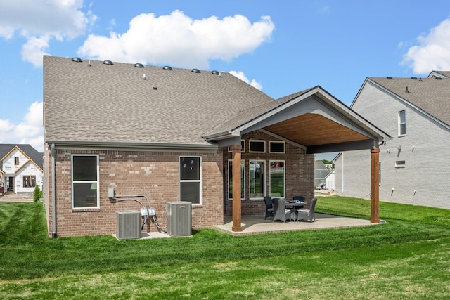 back of property featuring brick siding, a yard, central air condition unit, and a patio