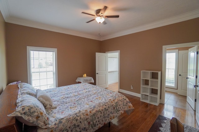 bedroom featuring wood finished floors, baseboards, ornamental molding, and multiple windows
