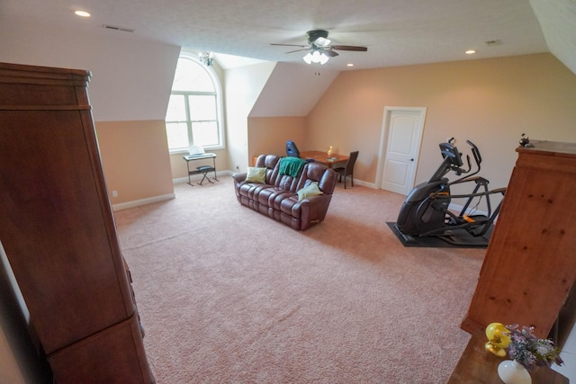 interior space with ceiling fan, visible vents, vaulted ceiling, baseboards, and carpet floors