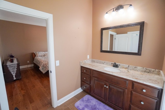 bathroom with baseboards, wood finished floors, and vanity