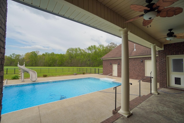 view of pool featuring fence, a ceiling fan, a water slide, and a fenced in pool