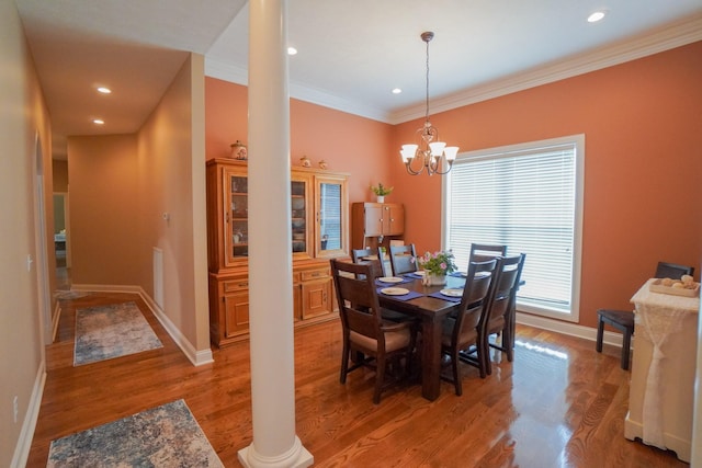 dining room featuring crown molding, baseboards, decorative columns, and light wood-type flooring