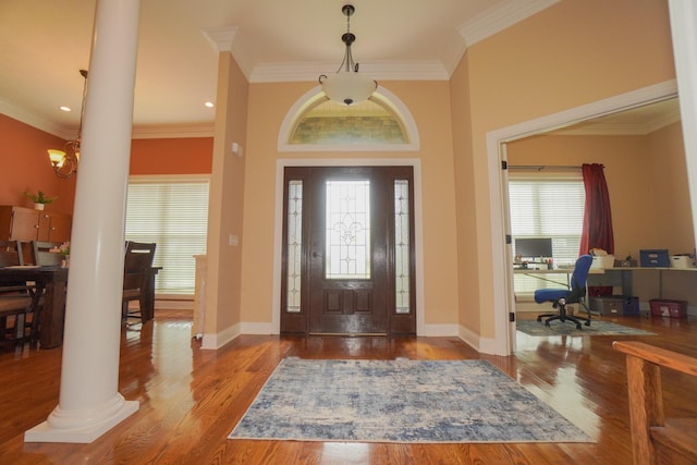entryway with crown molding, decorative columns, wood finished floors, and baseboards