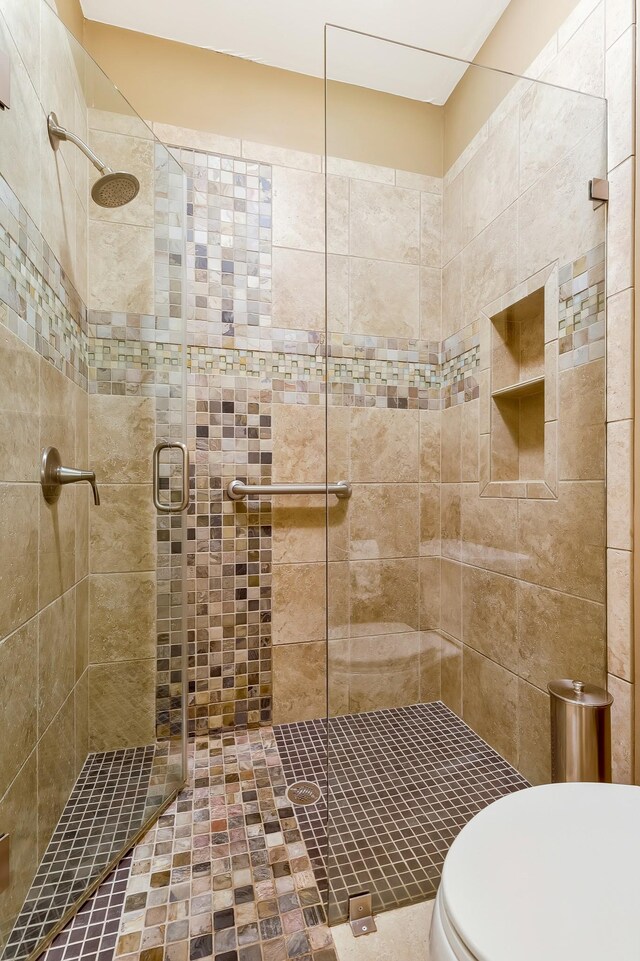 bathroom featuring a shower stall and toilet