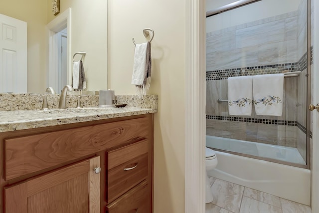 full bathroom featuring shower / bath combination with glass door, vanity, marble finish floor, and toilet