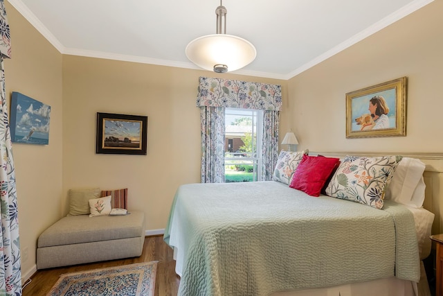 bedroom featuring ornamental molding, baseboards, and wood finished floors