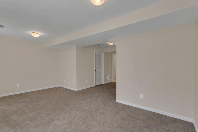 spare room with carpet floors, baseboards, and visible vents