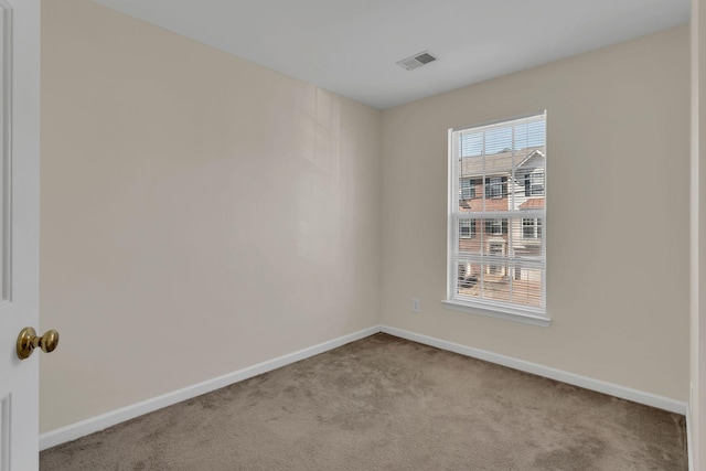 carpeted spare room featuring visible vents and baseboards