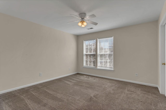 spare room with visible vents, baseboards, a ceiling fan, and carpet flooring