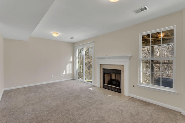 unfurnished living room with a fireplace with flush hearth, carpet, visible vents, and baseboards