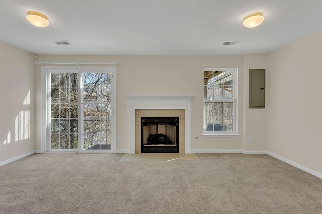 unfurnished living room with visible vents, carpet flooring, and electric panel