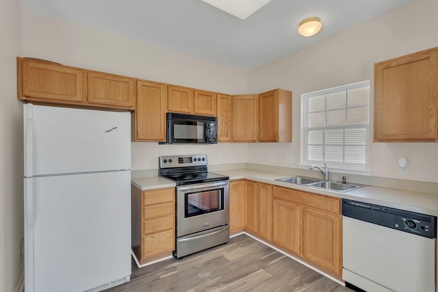 kitchen with freestanding refrigerator, dishwashing machine, black microwave, a sink, and stainless steel electric range