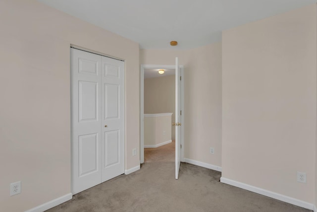 unfurnished bedroom featuring a closet, baseboards, and carpet