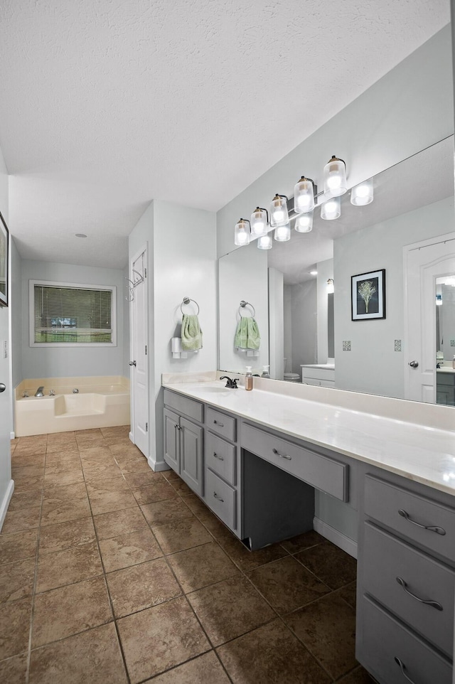 2321 Chimney Hills Dr, Soddy Daisy, TN 37379 - bathroom featuring double vanity, a garden tub, tile patterned flooring, a textured ceiling, and baseboards