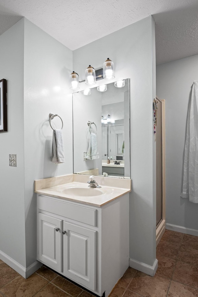 2321 Chimney Hills Dr, Soddy Daisy, TN 37379 - bathroom featuring vanity, a textured ceiling, baseboards, a shower with shower door, and tile patterned flooring