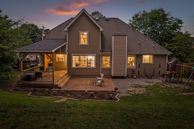 2321 Chimney Hills Dr, Soddy Daisy, TN 37379 - back of property at dusk featuring a patio, a playground, a lawn, and a wooden deck