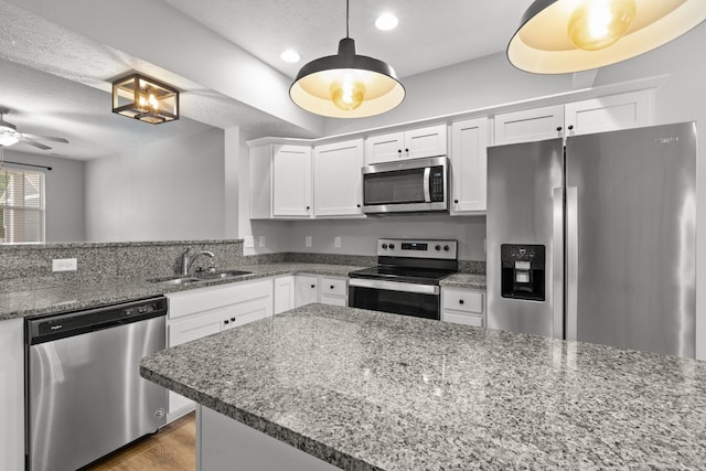 kitchen featuring white cabinetry, a ceiling fan, appliances with stainless steel finishes, and a sink