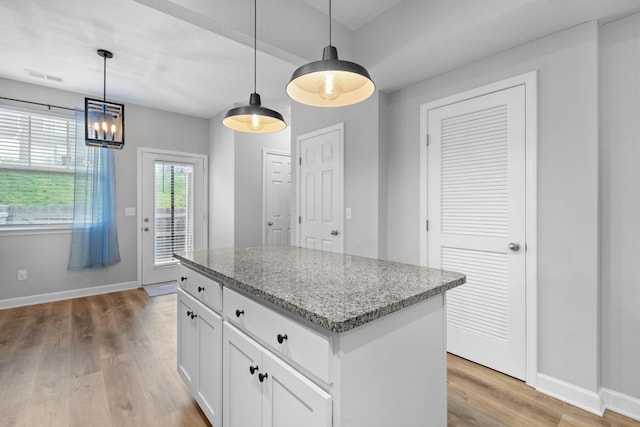 kitchen with visible vents, light wood-type flooring, baseboards, and a center island