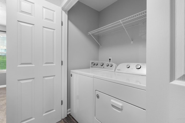 washroom featuring washing machine and clothes dryer, laundry area, and baseboards