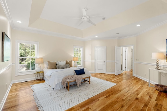 203 Tom Robinson Rd, Franklin, TN 37064 - bedroom featuring a tray ceiling, multiple windows, and light wood-style floors